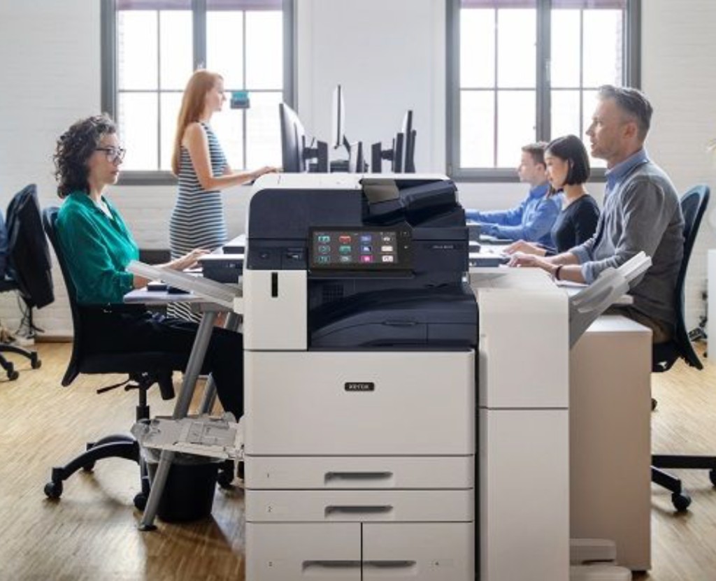 Office team working around a Xerox® AltaLink® B8255 multifunction printer in a modern workspace